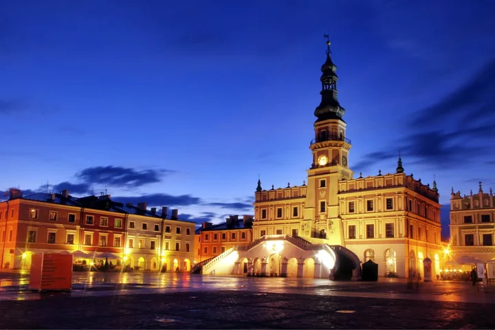 Grafika promocyjna wydarzenia Zamość–Bełżec: wycieczka do Miejsca Pamięci i renesansowego Zamościa (21 grudnia 2025)